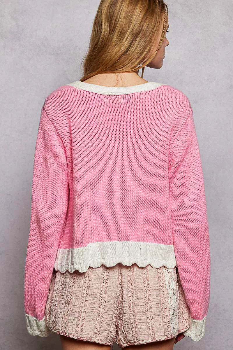 Barbie pink cardigan draped over arm highlighting soft acrylic knit