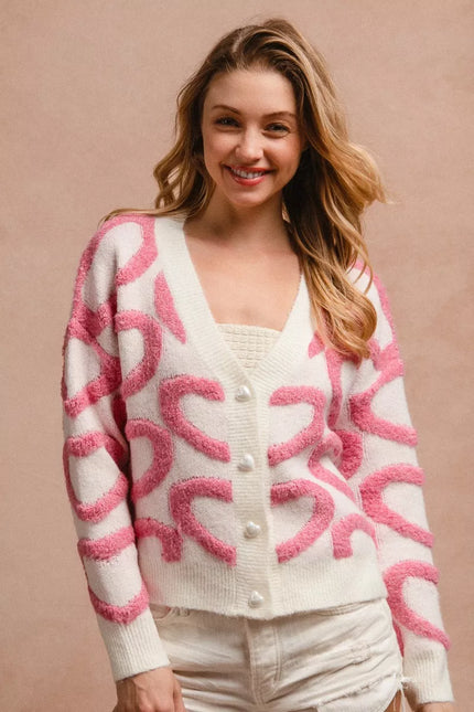 Pink and cream textured heart patterned buttoned v neck cardigan with cozy knit fabric.