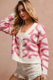 Pink heart patterned textured cardigan with button closure and v-neck fit