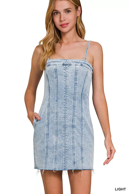 Light-wash denim dress with exposed seams, spaghetti straps, and frayed hem.