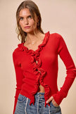 Red ribbed sweater with cascading ruffles, fitted silhouette, textured knit fabric.