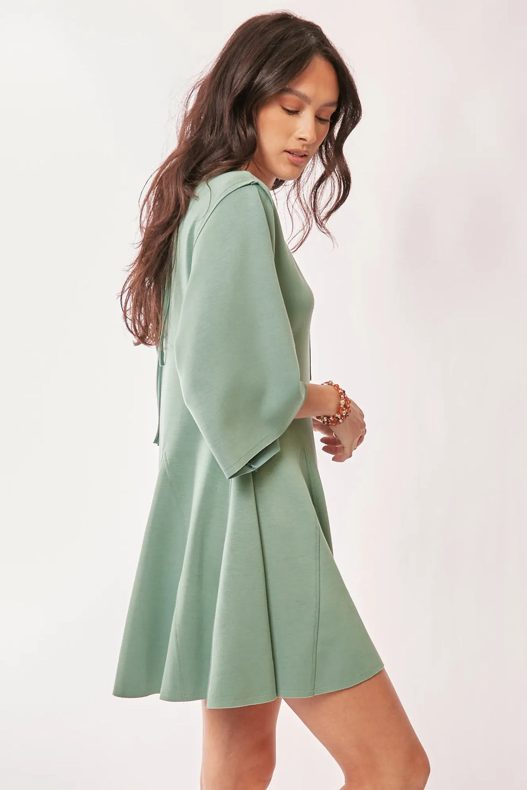 A-line romper in seafoam green showcasing draped sleeves and light material