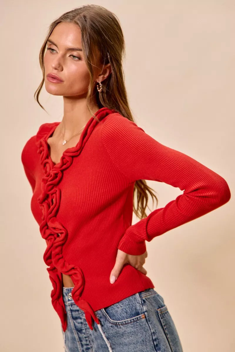 Vibrant red ribbed knit cardigan with cascading ruffles, fitted silhouette, denim pairing