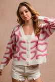 Pink heart patterned textured knit cardigan with pearl buttons and relaxed fit