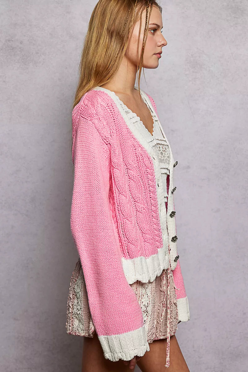 Relaxed fit pink cardigan showcasing cable stitching and button placement