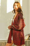 Shimmering red metallic knit V-neck cardigan with loose fit and textured open front.