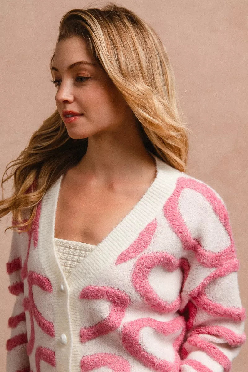 White and pink textured heart patterned buttoned V neck cardigan with soft knit fabric fit.