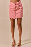Pink vintage wash denim mini skirt with scalloped hem and front button closure