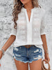 white blouse with eyelet detailing and notched flounce sleeves on a mannequin