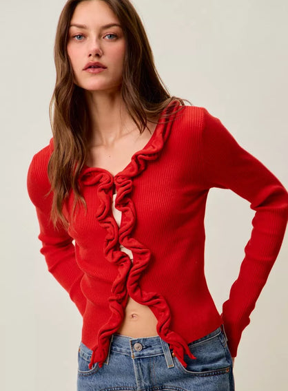 Red ribbed sweater with ruffled front, fitted, showing midriff, paired with jeans