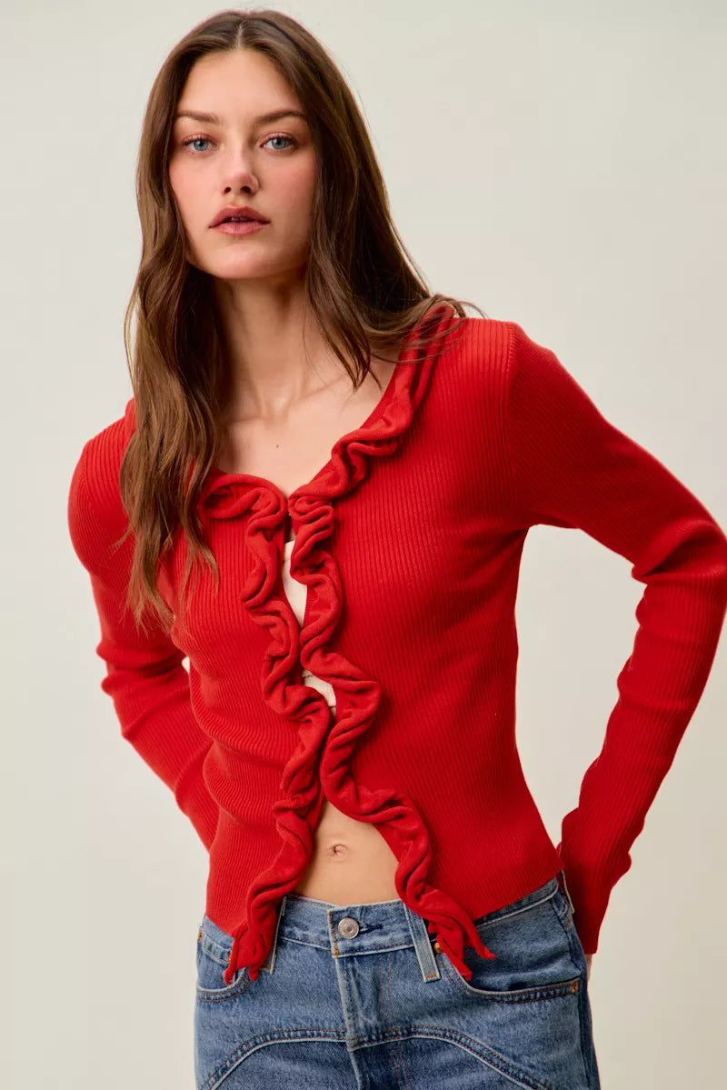 Red ribbed sweater with ruffled front, fitted, showing midriff, paired with jeans