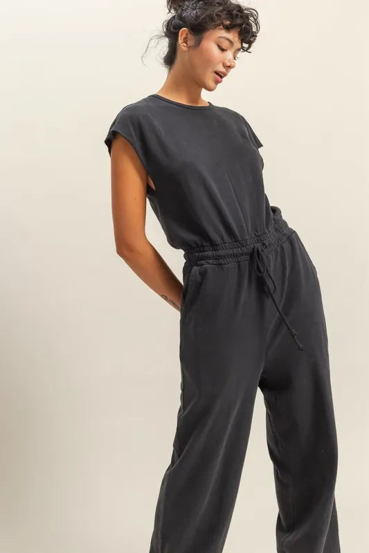 Close-up of black jumpsuit drawstring waist and side pockets
