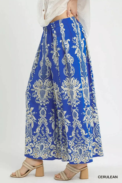 Flowy blue wide-leg pants with gold embroidered paisley border, elegant high-block sandals, soft sheer long sleeves