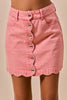 Pink vintage wash denim mini skirt with scalloped hem and front button closure