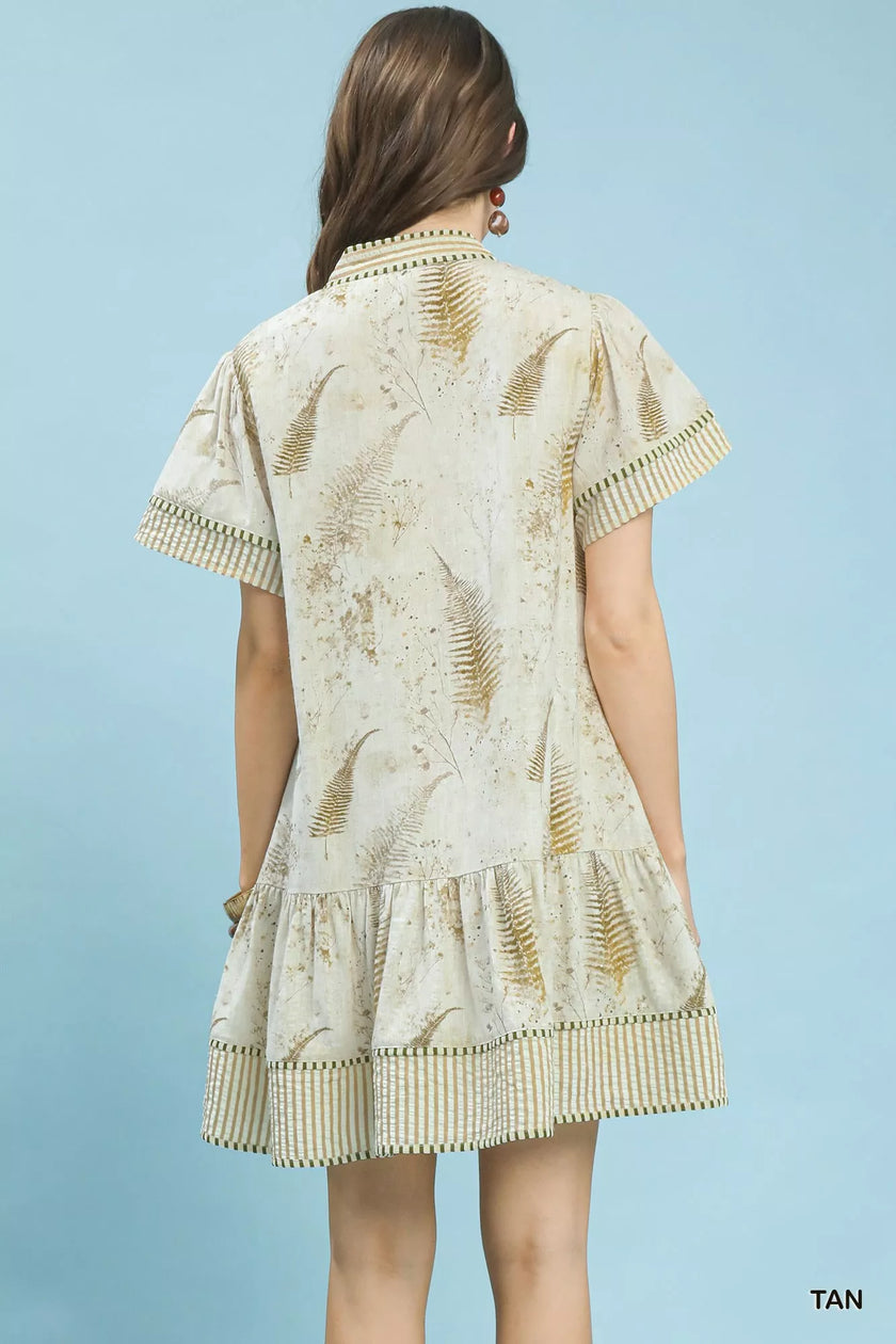 Tan linen dress with fern print, tiered hem, short sleeves, and side pockets