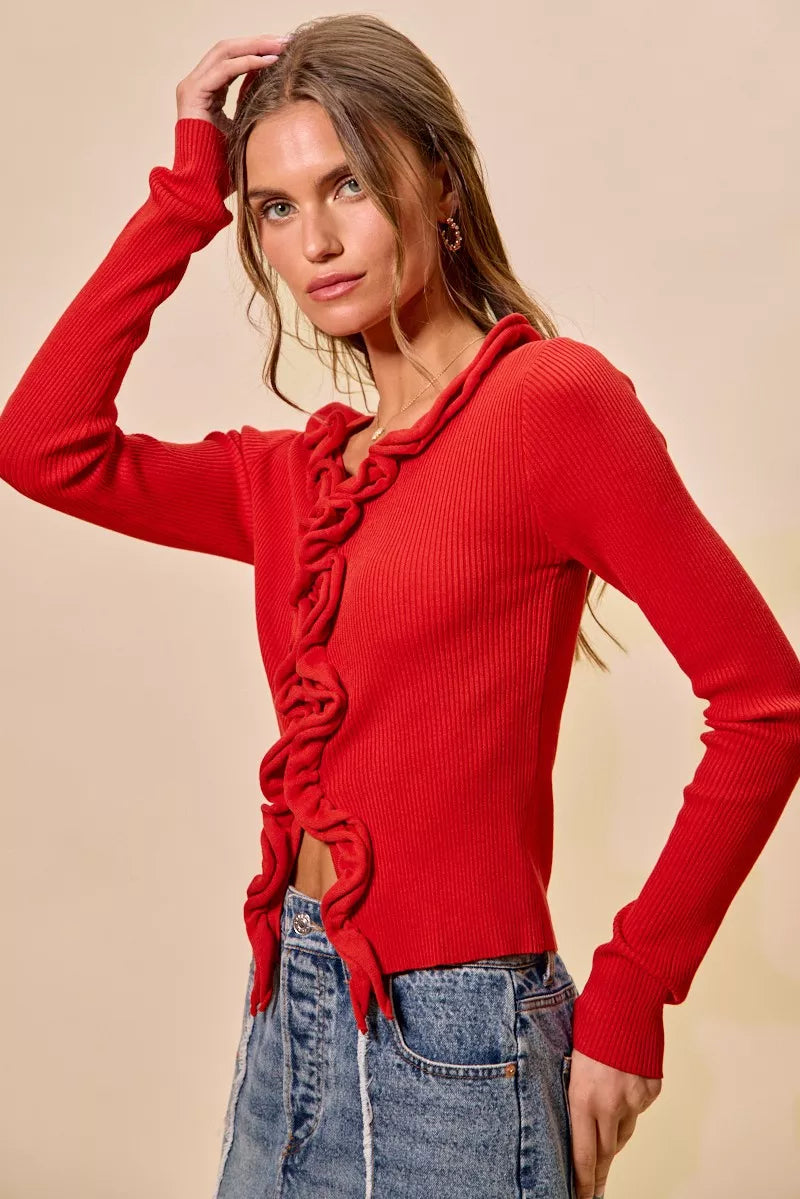 Vibrant red ribbed sweater with cascading ruffles, fitted silhouette, denim pairing.