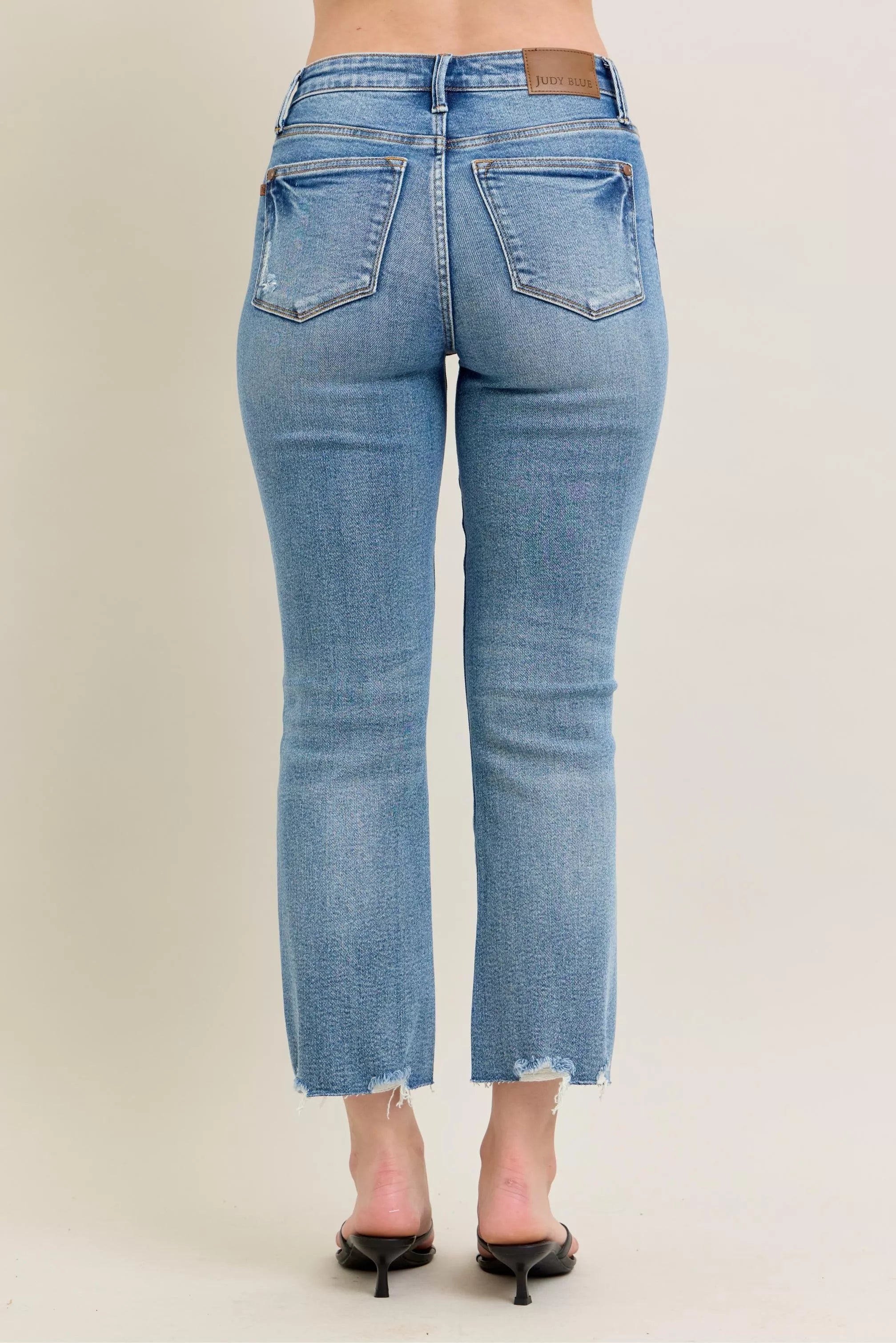 Light blue vintage wash denim jeans with frayed hem and kick flare fit
