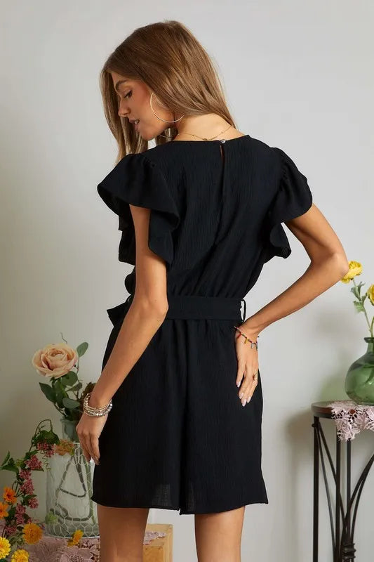 Close-up of ruffled sleeve detail on black romper