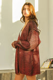 Shimmering red metallic knit V-neck cardigan, loose fit, textured open front.