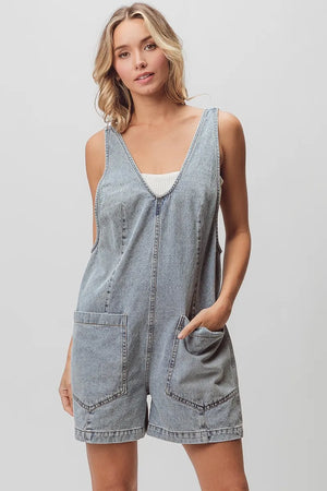 Light-wash denim shortall with patch pockets, relaxed fit, textured fabric, vintage wash.