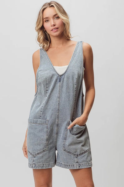 Light-wash denim shortall with patch pockets, relaxed fit, textured fabric, vintage wash.