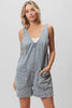 Light-wash denim shortall with patch pockets, relaxed fit, textured fabric, vintage wash.