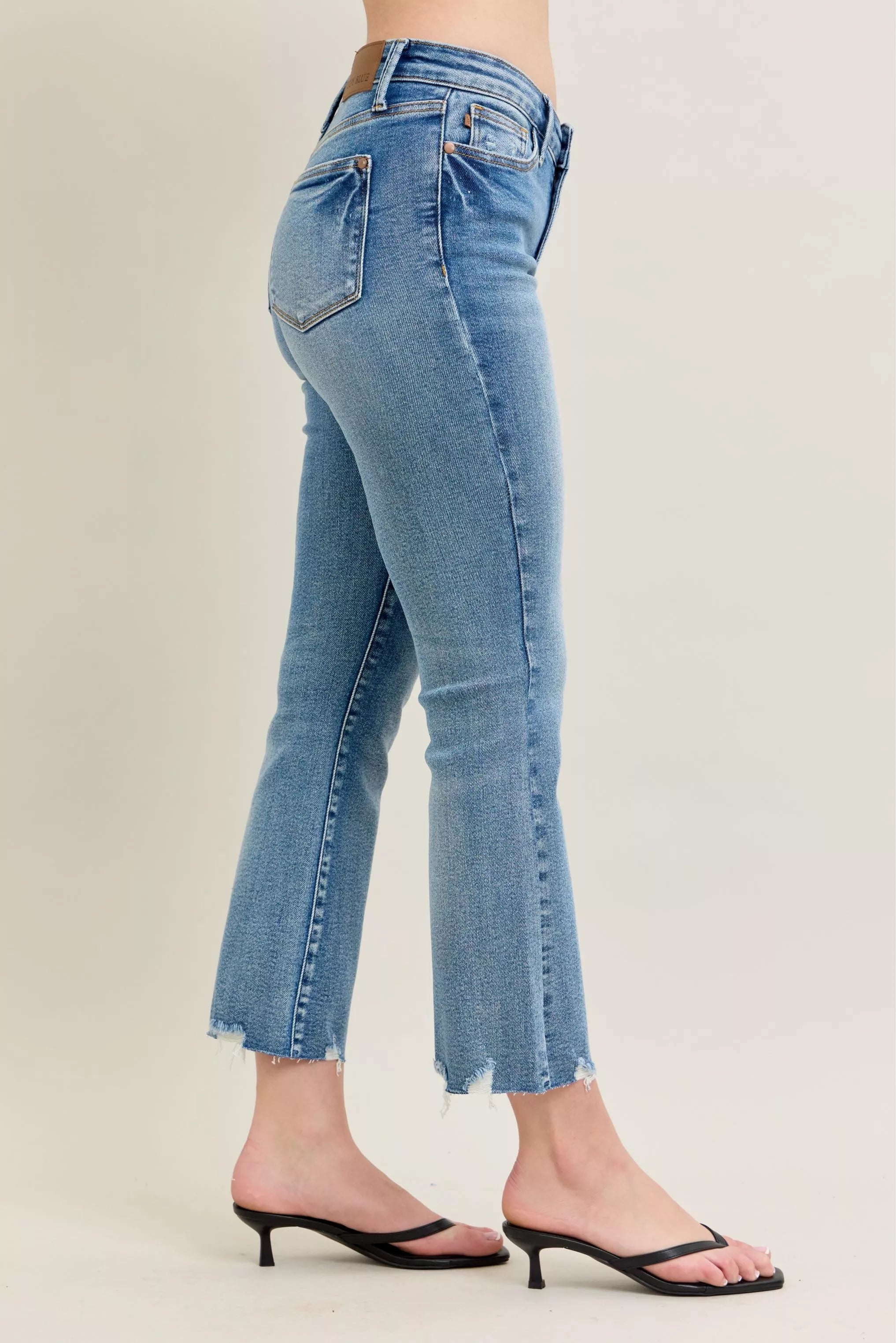 Light blue vintage wash denim jeans with frayed hem and kick flare fit