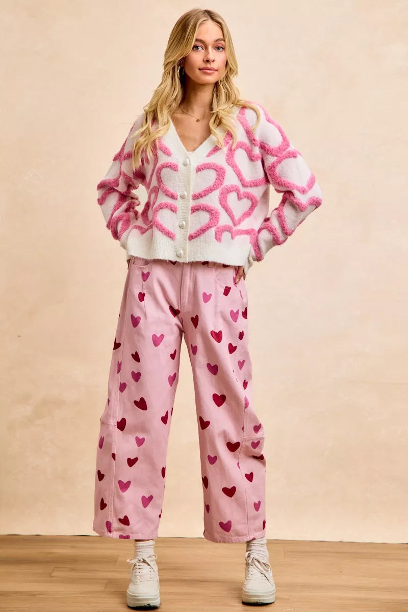 Pink textured heart cardigan with button closure, cropped fit, cozy knit fabric.