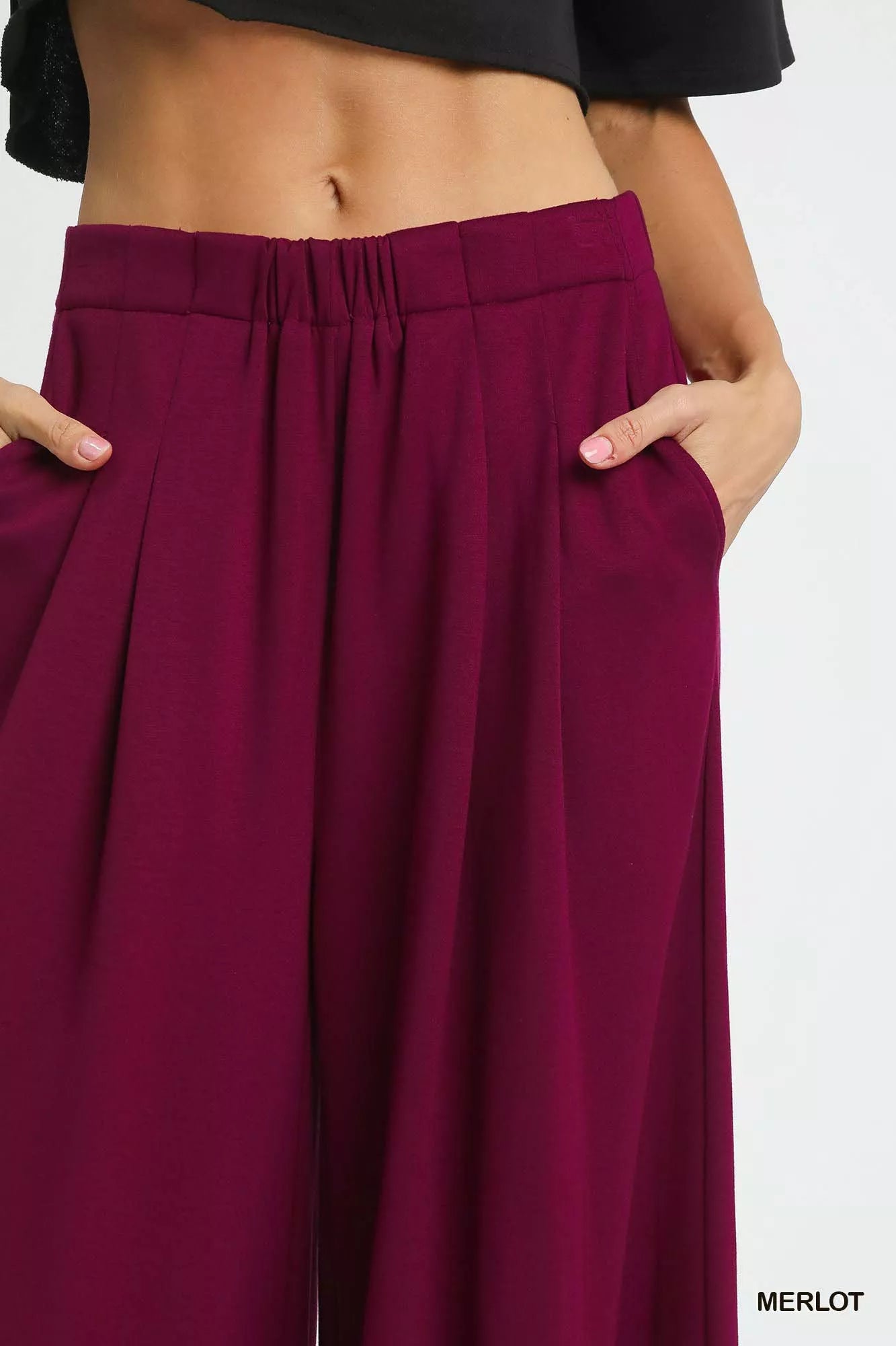 Wide-leg pants in merlot red displayed with clean modern lines