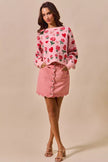 Pink vintage wash denim mini skirt with scalloped hem and front button closure