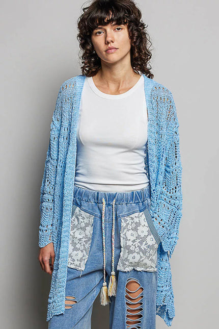 Light blue openwork cardigan with scalloped edge, loose fit, crochet texture, layered over white top and ripped jeans.