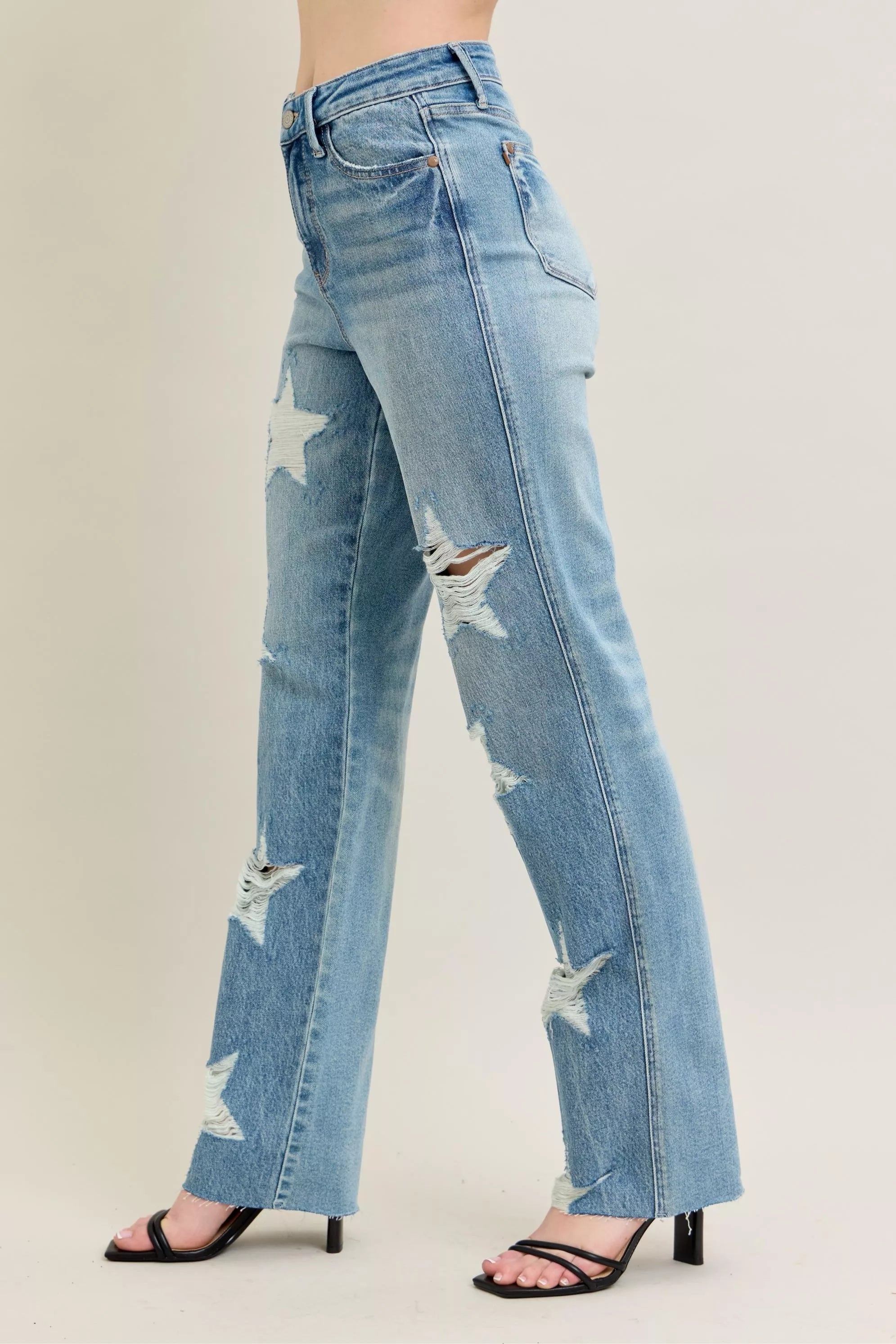 High-waisted 90s-style rigid denim jeans with star distressing, plus fit, light blue wash.
