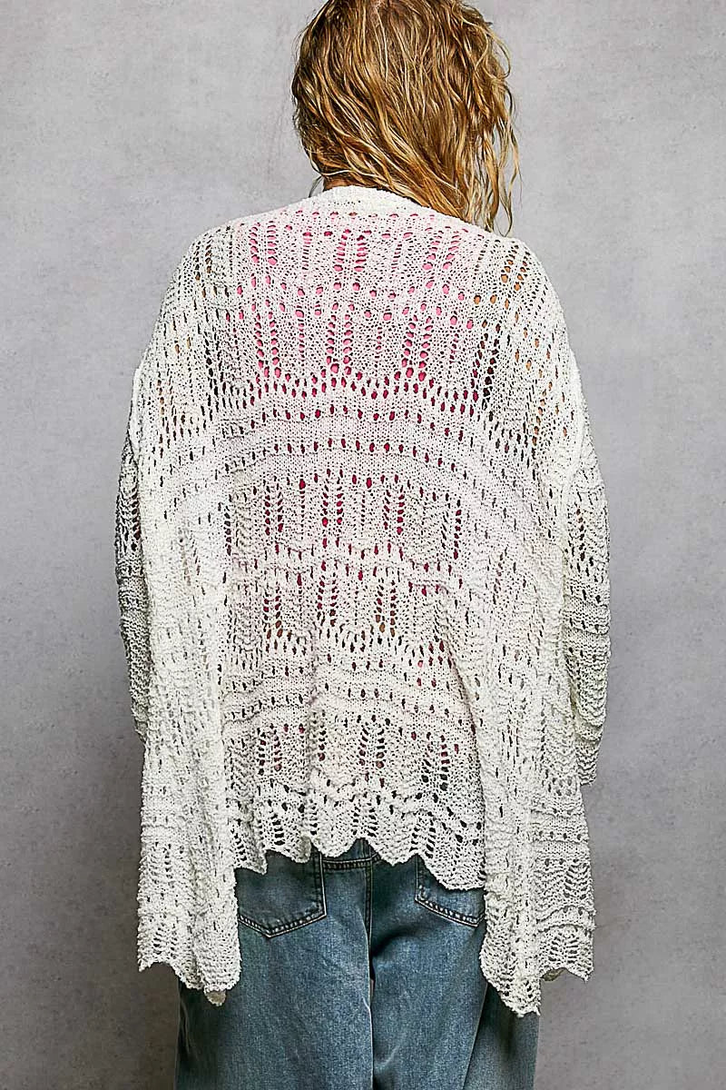 White openwork knit cardigan with scalloped hem, loose fit, pink inner layer visible