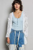 White openwork cardigan with scalloped edge, lightweight knit, loose fit over light blue top.