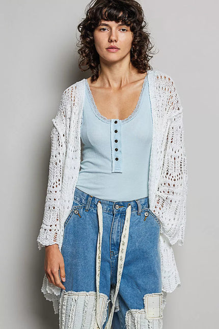 White openwork cardigan with scalloped edge, lightweight knit, loose fit over light blue top.