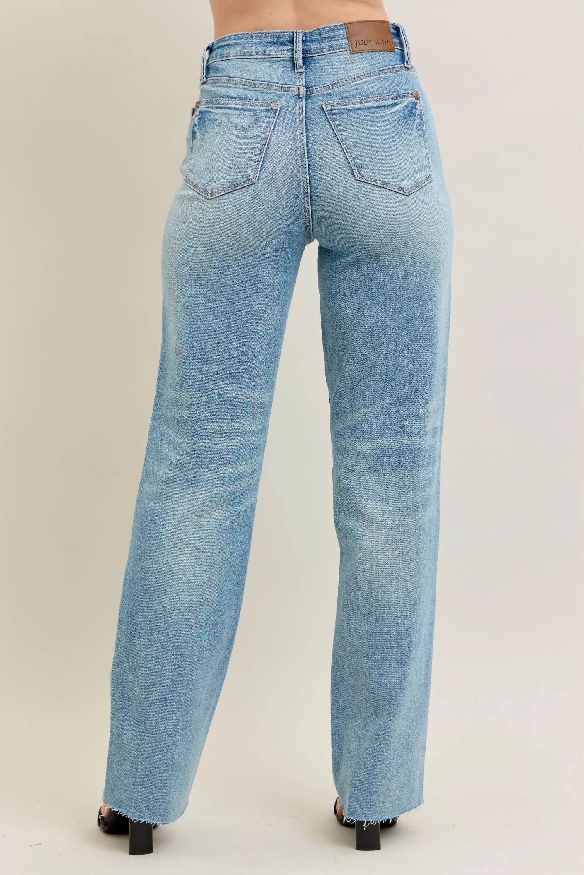 High-waisted 90s straight rigid distressed denim jeans, light blue wash, plus size, tailored fit with back pocket branding.