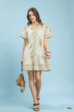 Tan linen dress with fern print, button front, tiered skirt, short sleeves, and side pockets