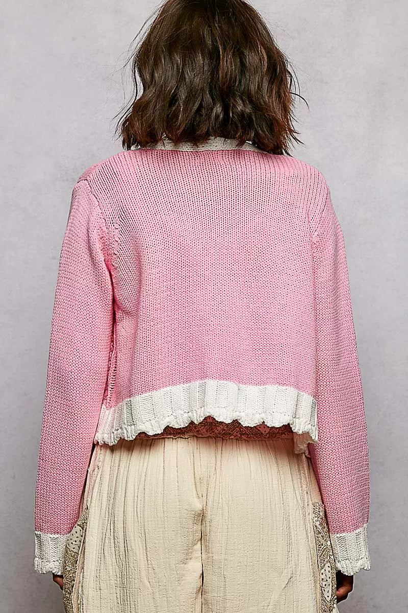 Barbie pink cardigan draped over arm showing knit texture