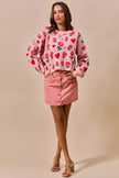 Pink vintage wash denim mini skirt with scalloped hem and front button closure