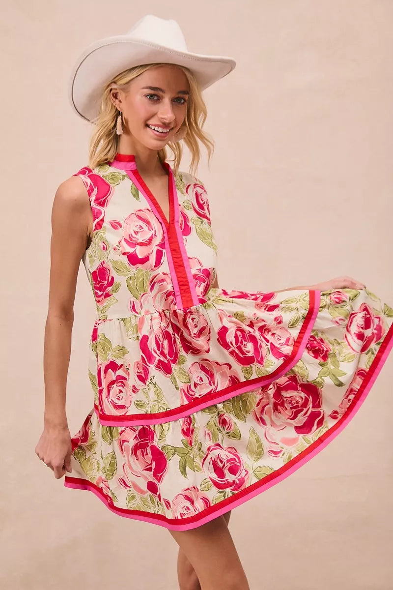Front view of coral pink floral mini dress with tiered ruffles