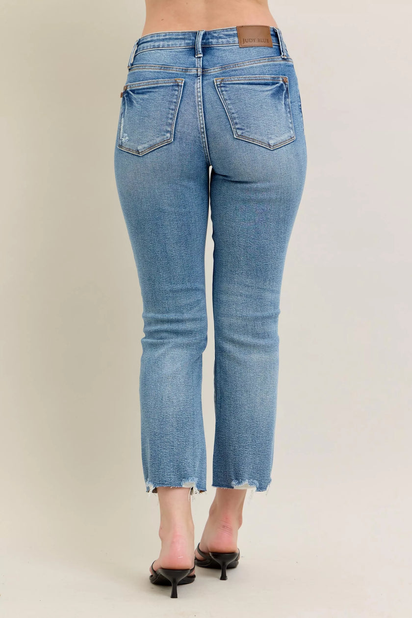 Light blue denim jeans with distressed hem and vintage wash texture, slim fit with kick flare.