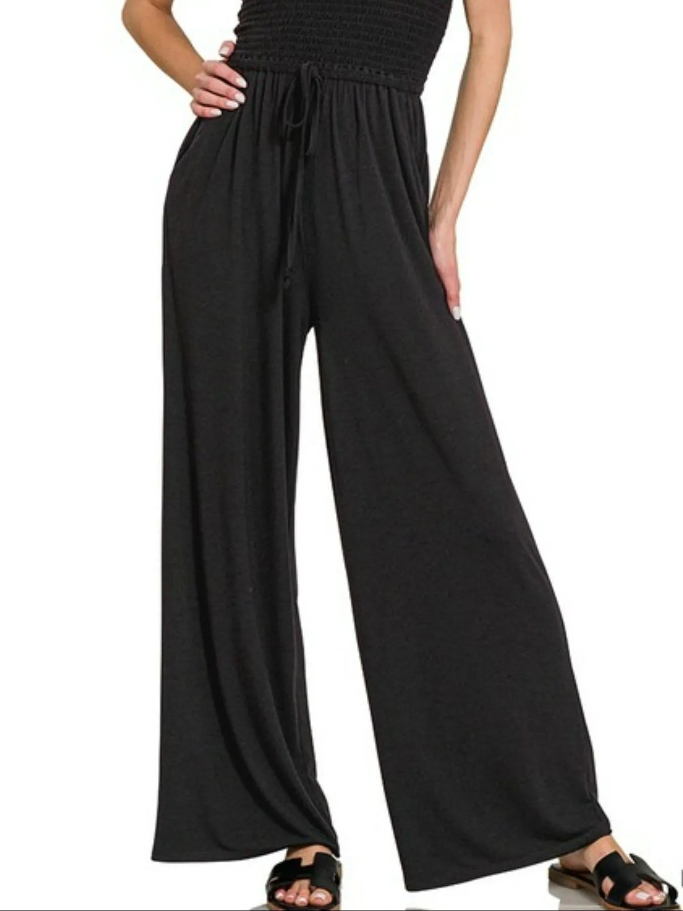 Close-up of elastic smocked waistline on charcoal black jumpsuit