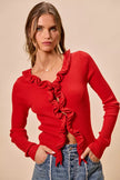 Vibrant red ribbed sweater with cascading ruffles, fitted, long sleeves, denim pairing.