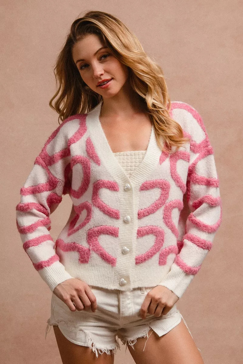 Pink textured heart pattern cardigan with pearl buttons and relaxed fit.