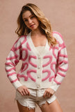 Pink textured heart pattern cardigan with pearl buttons and relaxed fit.