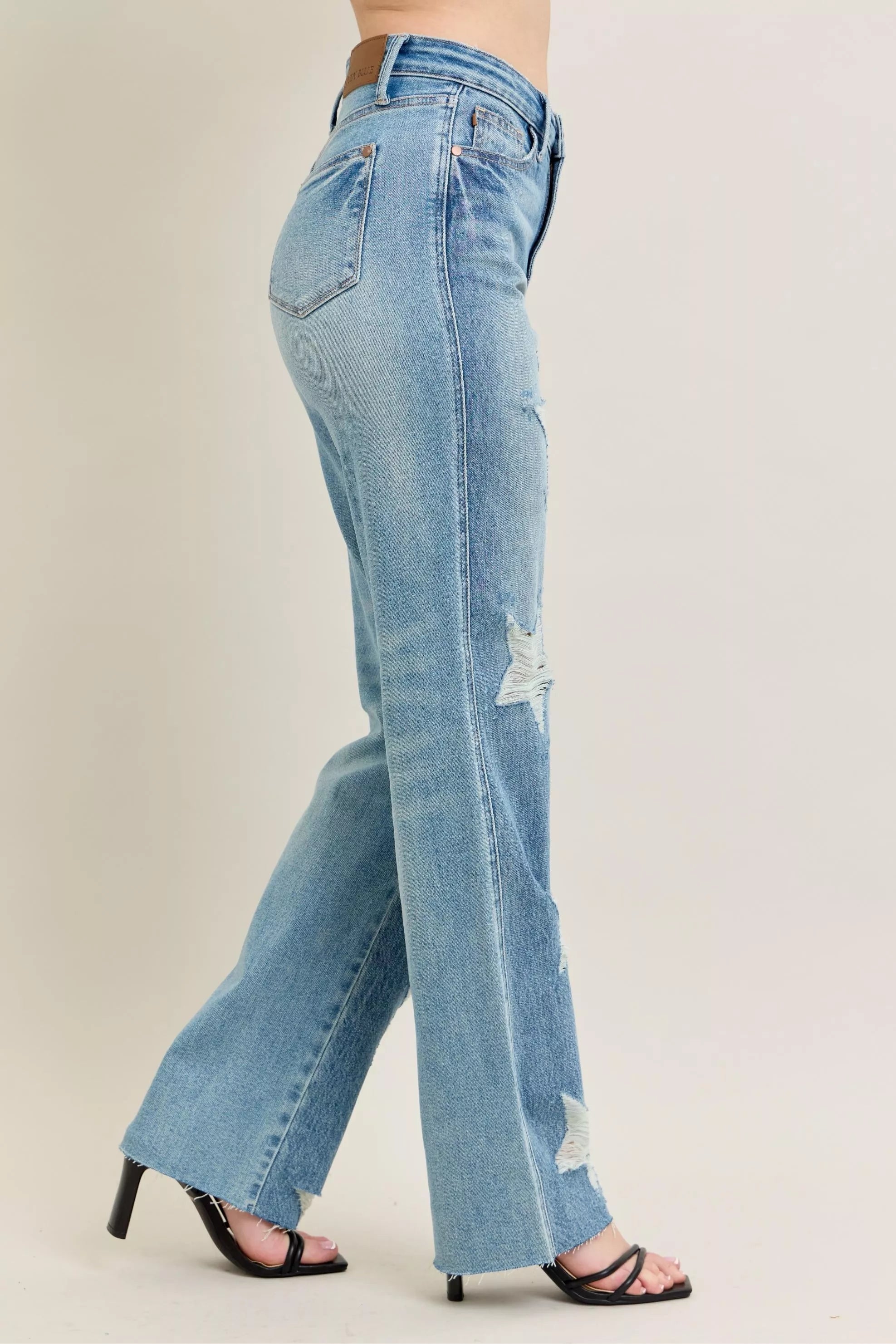High-waisted rigid distressed denim jeans, 90s straight fit, light blue with strategic rips, plus size.