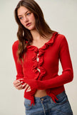 Red ribbed sweater with cascading ruffles, fitted cropped cardigan, denim pair
