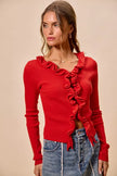 Vibrant red ribbed knit cardigan with cascading ruffles, fitted silhouette, denim pairing.
