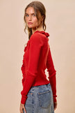 Red ribbed sweater with ruffle detailing, fitted silhouette, denim pairing