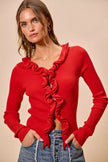 Red ribbed knit cardigan with cascading ruffles, fitted silhouette, denim pairing.